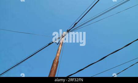 Elektrische Pole und Kabel, von unten nach oben gesehen Stockfoto