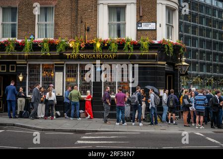 London, Vereinigtes Königreich: Der Sugarloaf Pub an der Ecke Cannon Street und Queen Street in der City of London. Die Leute stehen vor dem Pub und genießen einen Drink. Stockfoto