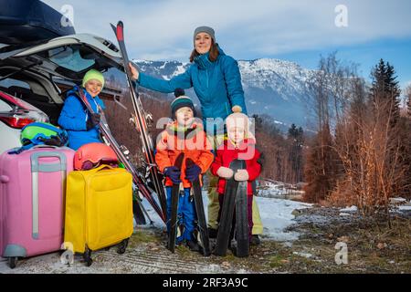 Mutter am Urlaubsstand mit Ski im Auto kam mit 3 Kindern an Stockfoto