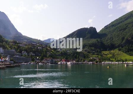 Blick auf das kleine Touristendorf Geiranger vom Kreuzfahrtschiff, das in der Region Geiranger Fjord Sunnmøre im Bezirk Møre Og Romsdal in Norwegen festgemacht ist Stockfoto