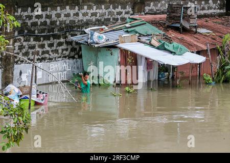 Provinz Bulacan. 31. Juli 2023. Ein Einwohner weht am 31. Juli 2023 in der Provinz Bulacan auf den Philippinen durch Überschwemmungen. Die Zahl der Todesopfer durch Überschwemmungen und Erdrutsche, die durch den Taifun Doksuri ausgelöst wurden, stieg auf 25, wobei mindestens 20 weitere fehlten, sagte die nationale Katastrophenbehörde der Philippinen am Montag. Kredit: Rouelle Umali/Xinhua/Alamy Live News Stockfoto