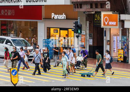 Fußgänger überqueren die Straßenkreuzung in Wanchai, Hongkong, SAR, China Stockfoto