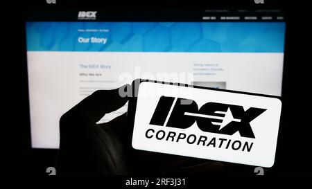 Person, die ein Smartphone mit dem Logo des US-amerikanischen Fertigungsunternehmens IDEX Corporation auf dem Bildschirm vor der Website hält. Konzentrieren Sie sich auf das Display des Telefons. Stockfoto