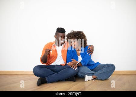 Glückliches schwarzes Paar, das den Schlüssel aus seinem neuen Zuhause sieht Stockfoto