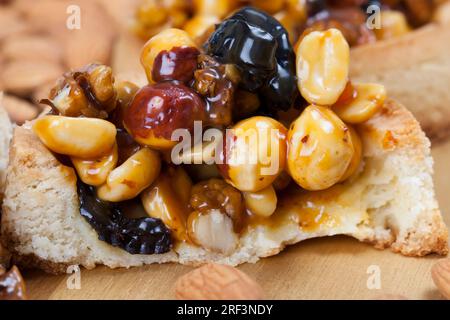 Knusprige Törtchen mit Haselnüssen, Erdnüssen und anderen Zutaten, Weizentörtchen mit Nüssen und getrockneten Früchten in Sahne-Karamell, Weizentörtchen mit Pfeffer Stockfoto