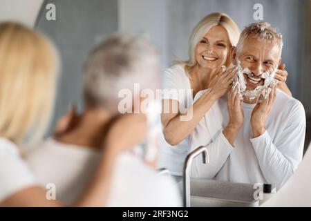 Happy Mature Ehepaar Amüsiert Sich, Während Es Sich Im Badezimmer Fertig Macht Stockfoto