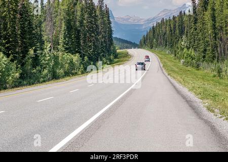 Fahrzeuge, die entlang der Autobahn durch den Banff National Park Canada fahren. Stockfoto