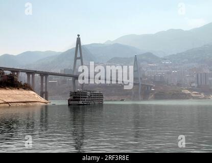 nebelige Landschaft entlang des Jangtse in China einschließlich der Brücke und touristischen Boot Stockfoto