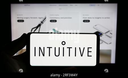 Person, die ein Smartphone mit dem Logo der US Medical Company intuitive Surgical Inc. Auf dem Bildschirm vor der Website hält. Konzentrieren Sie sich auf das Display des Telefons. Stockfoto