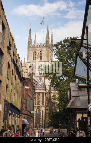 Ein Paar mittleren Alters, das eine hübsche Seitenstraße entlang läuft, die zur Southwark Cathedral in London, Großbritannien, führt Stockfoto