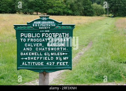 Antikes gusseisernes Fußwegschild aus dem Jahr 1908 der Peak District and NC Footpaths Society am Derwent Valley Way in Grindleford in Derbyshire Stockfoto
