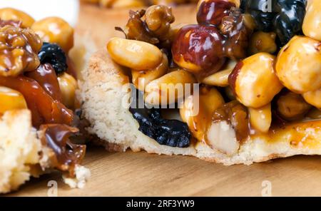 Weizentörtchen mit Nüssen und getrockneten Früchten in Sahne-Karamell, Weizentörtchen mit süßer Füllung, knusprige Törtchen mit Haselnüssen, Erdnüssen und anderen in Stockfoto