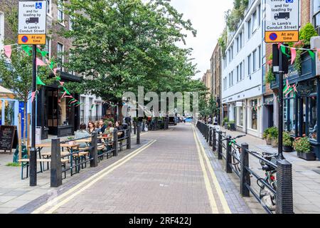 Ein Blick auf die Lamb's Conduit Street in Holborn, London, Großbritannien, mit Menschen, die im Freien in den Cafés und Restaurants im Mai essen Stockfoto