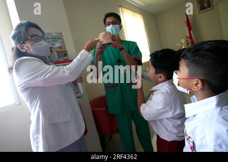 Zahnärzte informieren Grundschüler, die das Vania Bogor Hospital in Indonesien besuchen, über die Aufrechterhaltung der Zahnhygiene und -Gesundheit Stockfoto