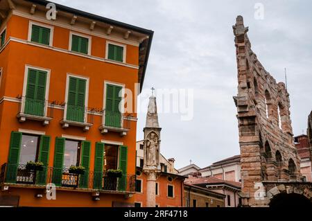 Mauer der Verona Arena und Monument Colonna con capitelli in Verona, Italien. Stockfoto