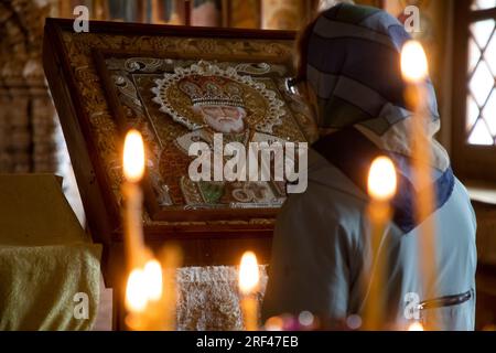 Tutajew-Stadt, Region Jaroslawl, Russland. 30., Juli 2023. Eine Frau betet vor einer Ikone in der Auferstehungskathedrale in Tutaev (früher hieß die Stadt Romanow-Borisoglebsk), Russland Stockfoto