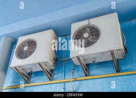 Weiße Klimaanlagen an der blauen Wand des Hauses. Moderne Klimaregelungstechnologien Stockfoto