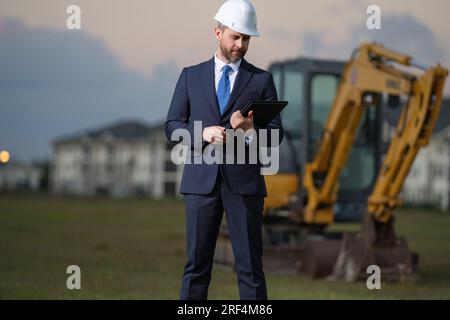 Buider-Mann in Anzug und Schutzhelm. Bauinvestor. Geschäftsmann-Investor vor der Baustelle. Erfolgreicher Investor. Ein hübscher Mann im Anzug Stockfoto