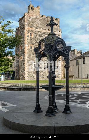 Springbrunnen in Stranraer zum Diamantenjubiläum von Königin Victoria. Dahinter befindet sich das Schloss St. John, auch bekannt als Schloss Stranraer. Stockfoto