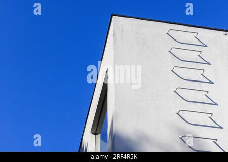 Ecke weißer Wände mit Metalltreppen unter blauem Himmel, Feuertreppe. Abstrakter Architekturhintergrund. Stockfoto
