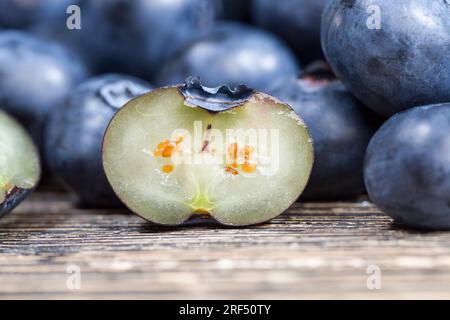 Frische, geschnittene Heidelbeeren, die roh gegessen werden können, geschnittene Heidelbeeren mit hohem Vitamingehalt, frisch geerntete und leckere Heidelbeeren in zwei Hälften geschnitten Stockfoto