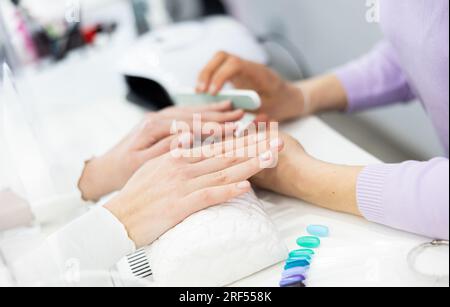 Frau Hände, mit denen die Maniküre Master Feilen Nägel Stockfoto