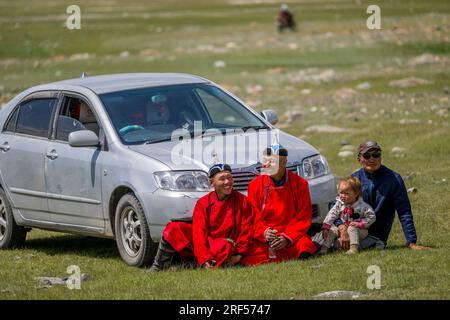 Menschen in traditionellen Kleidern warten auf den Beginn eines lokalen Naadam Festivals im Sagsai-Tal, einem abgelegenen Tal im Altai-Gebirge (Altay Stockfoto