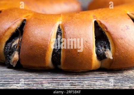 Frisches Brötchen mit schwarzem Mohnsamen Füllung, Nahaufnahme eines köstlichen frischen Weizenbrötchens, Mohnsamen und Ei Füllung in einem Dessertbrötchen Stockfoto