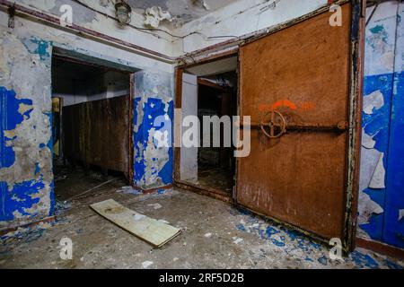 Zugang zum Bombenschutzbunker für den Zivilschutz. Große gepanzerte, explosionsgeschützte Türen mit Ventil. Stockfoto