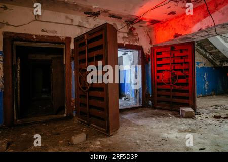 Zugang zum Bombenschutzbunker für den Zivilschutz. Große gepanzerte, explosionsgeschützte Türen mit Ventil. Stockfoto