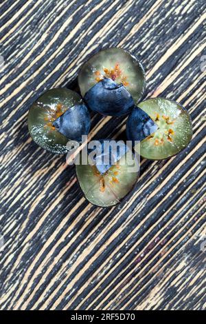 Frisch geerntete und leckere Heidelbeeren in zwei Hälften geschnitten, frisch geschnittene Heidelbeeren, die roh verzehrt werden können, geschnittene Heidelbeeren mit hohem Vitamingehalt Stockfoto