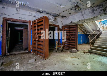 Zugang zum Bombenschutzbunker für den Zivilschutz. Große gepanzerte, explosionsgeschützte Türen mit Ventil. Stockfoto