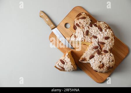 Köstlicher italienischer Ostertaubenkuchen (traditionell Colomba di Pasqua) und Messer auf einem leichten Tisch, Blick von oben. Platz für Text Stockfoto