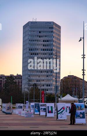 Genf, Schweiz - 25. März 2022: Politische Banner bei der monumentalen Skulptur Broken Chair vor dem UN-Büro in Genf, Schweiz. Stockfoto