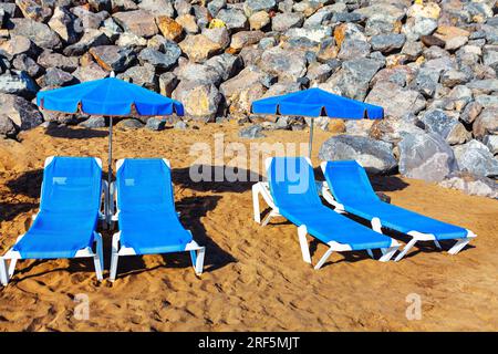 Liegen und Sonnenschirme am Meer. Sommerferienkonzept Stockfoto