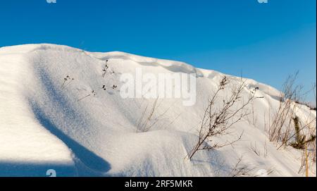 Große Schneewehen nach Schneefällen und Schneestürmen, die Wintersaison mit kaltem Wetter und vielen Niederschlägen in Form von Schnee Stockfoto