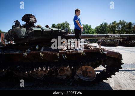 Kiew, Ukraine. 28. Juli 2023. Ein Junge steht auf einem zerstörten russischen Panzer in Zentral-Kiew. (Foto: Oleksii Chumachenko/SOPA Images/Sipa USA) Guthaben: SIPA USA/Alamy Live News Stockfoto