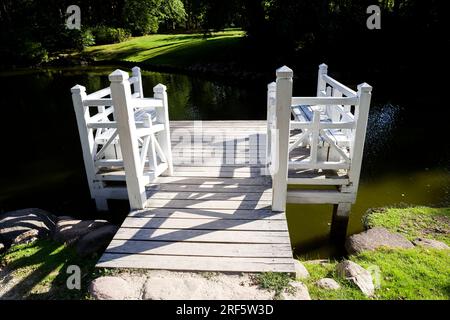 Mit weißer Farbe bemalt, Teil eines kleinen Pavillons zum Entspannen im Park, eine Holzstruktur in weißer Farbe, sticht vor dem Hintergrund von pla hervor Stockfoto