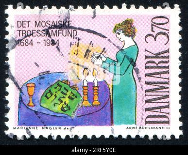 DÄNEMARK - CIRCA 1984: Stempel gedruckt von Dänemark, zeigt Frau Segen Sabbat Kerzen, circa 1984 Stockfoto