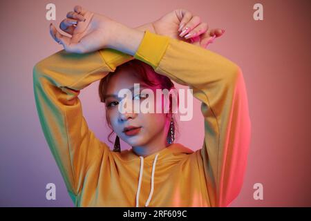 Porträt einer schweren jungen Transgender-Frau im Neonlicht Stockfoto