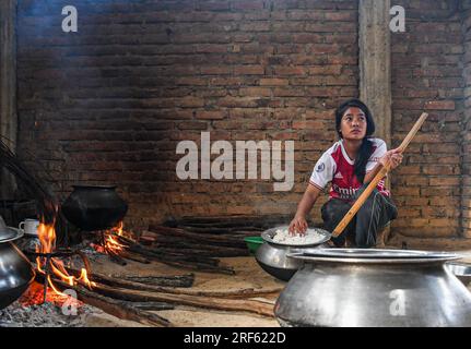 Churachandpur, Indien. 25. Juni 2023. NAO Chowng, 21, bereitet Reis für Freiwillige zu, die die Grenze vor dem Feind im Dorf Dampi in Churachandpur im nordöstlichen indischen Staat Manipur schützen. Der Bezirk Churachandpur und die gesamte Hügelgegend beherbergen viele Stämme, von denen die meisten Christen sind. Die Frauen in diesem Gebiet bereiten das Essen zu und kümmern sich um die Männer, die für die Bewachung der Dörfer verantwortlich sind. (Foto: Biplov Bhuyan/SOPA Images/Sipa USA) Guthaben: SIPA USA/Alamy Live News Stockfoto