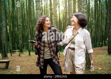 Zwei asiatische Frauen, die zusammen im Wald wandern. Reiseaktivität Stockfoto