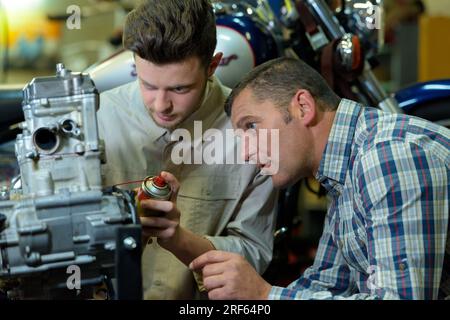 Männer, die an einem kaputten Motor arbeiten Stockfoto