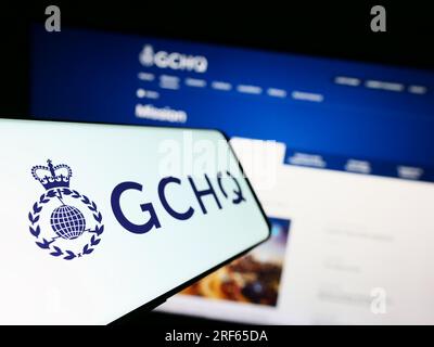 Smartphone mit Logo der Government Communications Headquarters (GCHQ) auf dem Bildschirm vor der Website. Fokus auf der linken Seite des Telefondisplays. Stockfoto