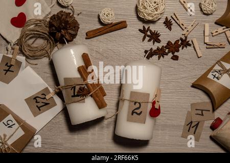 Eine nicht erkennbare junge Frau malt Zahlen auf Kerzen. Frau macht hausgemachte Adventskalender mit eigenen Händen gemacht Schritt für Schritt selbstgemachtes Kunsthandwerk Machen Sie es selbst. Vorbereitung auf das weihnachtskonzept. Saisonale Aktivitäten für Kinder, Familienurlaub im Winter. Umweltfreundlich Geschenke. Öffnen Sie das Paket jeden Tag Stockfoto