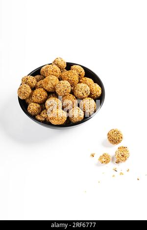 Sesam Ladoo oder Ellunda oder Til ladoo, ein traditionelles indisches süßes Leckerli aus Sesamsamen und Zierkerzen, isoliertes Bild mit weißem Hintergrund. Stockfoto