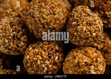 Sesam Ladoo oder Ellunda oder Til ladoo, ein traditionelles indisches süßes Leckerli aus Sesamsamen und Zierkerzen, isoliertes Bild mit weißem Hintergrund. Stockfoto