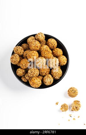 Sesam Ladoo oder Ellunda oder Til ladoo, ein traditionelles indisches süßes Leckerli aus Sesamsamen und Zierkerzen, isoliertes Bild mit weißem Hintergrund. Stockfoto