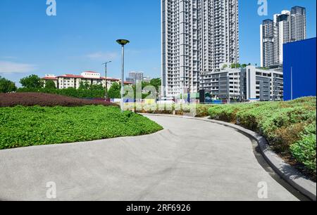 Geschwungener Betonweg in einem modernen Stadtgarten Stockfoto