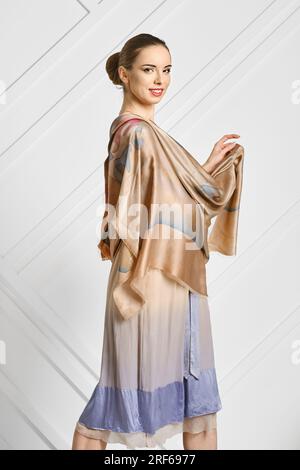 Fröhliche Frau mit Seidenschal, die im Profil posiert Stockfoto